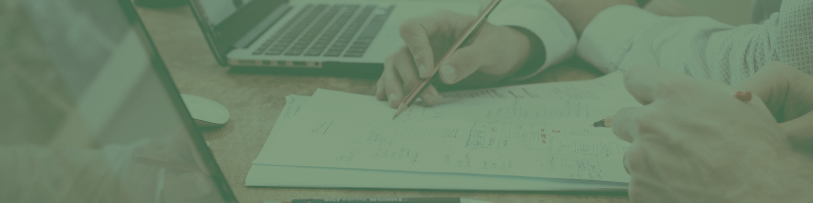 Two people diligently work on architectural plans, their hands holding pencils over printed diagrams, much like the meticulous craft of Melbourne web design. Nearby, a laptop hums quietly, almost anticipating a side of smashed avo to fuel their creativity.